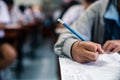 Students writing and reading exam answer sheets exercises in classroom of school with stress Royalty Free Stock Photo