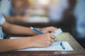 Students writing and reading exam answer sheets exercises in classroom of school with stress