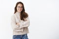 Studi shot of stylish creative and happy young european woman in glasses with perfect smile holding hands crossed over