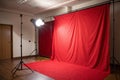Studio background, backdrop with wall and floor. Light spot on a red fabric background Royalty Free Stock Photo