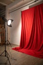 Studio background, backdrop with wall and floor. Light spot on a red fabric background Royalty Free Stock Photo