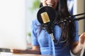 Studio black microphone in background woman sings closeup