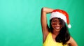 Studio bright summer portrait of beautiful smiling woman in Santa Claus hat over green background Royalty Free Stock Photo