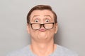 Studio close-up portrait of funny blond mature man with glasses, grimacing and making goofy crazy face, having fun, fooling around Royalty Free Stock Photo