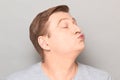 Portrait of funny mature man pouting his lips and blowing kiss