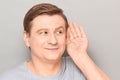 Portrait of happy man placing hand near ear and eavesdropping Royalty Free Stock Photo