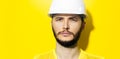 Studio close-up portrait of young serious man architect, builder engineer, wearing white construction safety helmet. Royalty Free Stock Photo