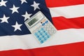 Studio close up shot of ruffled national flag with calculator over it - United States of America Royalty Free Stock Photo