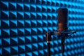 Studio condenser microphone on blue acoustic foam panel background Royalty Free Stock Photo