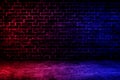 Studio dark room brick wall grunge texture background with red and blue lighting effect. Royalty Free Stock Photo