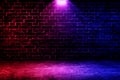 Studio dark room brick wall grunge texture background with red and blue lighting effect. Royalty Free Stock Photo