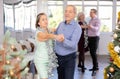 In studio decorated for New Year, elderly man and woman perky dance pair discofox.