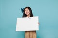 Studio of a delightful Asian girl holding a billboard