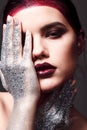 Studio fashion portrait of attractive woman with creative make-up and glitter and spangle on hands