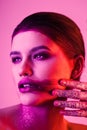 Studio fashion portrait of attractive woman with smeared lipstick and glitter and spangle on hands