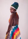 Studio fashion portrait of young African woman in summer dress and ethnic head wrap, white background Royalty Free Stock Photo