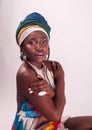 Studio fashion portrait of young African woman in summer dress and ethnic head wrap, white background Royalty Free Stock Photo