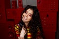 Studio fashion shooting.The girl in a bright outfit, top and pants flared in red and orange tones. Brunette with curly Royalty Free Stock Photo