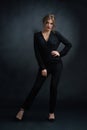 Studio frontview of confident woman wearing black suit.