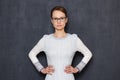 Portrait of serious young woman with glasses, holding hands on waist Royalty Free Stock Photo