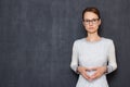 Portrait of serious focused young woman holding hands folded together Royalty Free Stock Photo