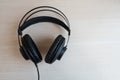 Studio headphones lying on a wooden table. Copy Space for text