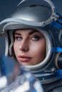 Female modern cosmonaut in spacesuit and helmet