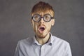 Studio headshot portrait of shocked young man in funny round glasses looking at camera Royalty Free Stock Photo