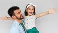 Studio horizontal image of happy daughter smiling broadly hold embrace his father with arms wide open. Loving daddy and his little Royalty Free Stock Photo