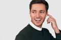 Young handsome man smiling and have a call with a colleague isolated on white wall holding wireless earphones with finger Royalty Free Stock Photo