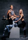 Sporty blond and brunette women and an athletic man over grey ba Royalty Free Stock Photo