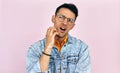 Studio image of a male wearing stylish casual clothes, transparent eyeglasses has thoughtful expression. Young man scratching his Royalty Free Stock Photo