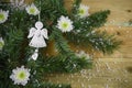 Christmas photography picture with tree branches and angel with love heart decoration and white winter flowers sprinkled with snow Royalty Free Stock Photo