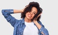 Studio image of pleased dark-skinned young woman dressed in blue shirt, holding hands on head, feels happy. African American Royalty Free Stock Photo