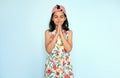 Studio image of a pretty kid praying with hands together has happy and thankful expression. A cute kid with hands folded in prayer