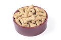 Studio lighting. dog food in the shape of a bone. a bowl of dark maroon color on a white backgroun