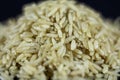 Studio macro shot of a pile of brown rice, also called complete, integral or wholegrain rice, with a blurred background. Brown