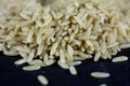 Studio macro shot of a pile of brown rice, also called complete, integral or wholegrain rice, with a blurred background. Brown Royalty Free Stock Photo