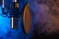 Studio microphone on mic stand against .Color disco background. Vocals and radio, podcasts, colored smoke Royalty Free Stock Photo