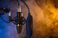 Studio microphone on mic stand against .Color disco background. Vocals and radio, podcasts, colored smoke Royalty Free Stock Photo