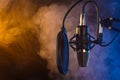 Studio microphone on mic stand against .Color disco background. Vocals and radio, podcasts, colored smoke Royalty Free Stock Photo