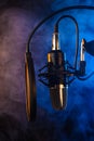 Studio microphone on mic stand against .Color disco background. Vocals and radios, podcasts, colored smoke. Vertical photo Royalty Free Stock Photo