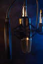 Studio microphone on mic stand against .Color disco background. Vocals and radios, podcasts, colored smoke. Vertical photo Royalty Free Stock Photo