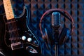 Studio microphone with professional headphones and black electric guitar Royalty Free Stock Photo