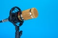 Studio microphone for recording podcasts, songs, and radio programs on a blue background with a place for inscription