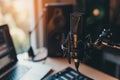 Studio microphone setup with warm daylight, laptop, and speakers in a home recording environment