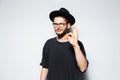 Studio photo of attractive young man, gesturing the OK sign, wearing black hat. Royalty Free Stock Photo