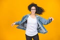 Studio photo of inspired africanamerican student lady dancing. Indoor portrait of relaxed black girl isolated on yellow background