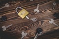 Studio photo of a lock with a broken key in it on a wooden background. Lots of other new keys around the lock Royalty Free Stock Photo