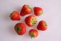 A studio photograph of seven freshly picked strawberries